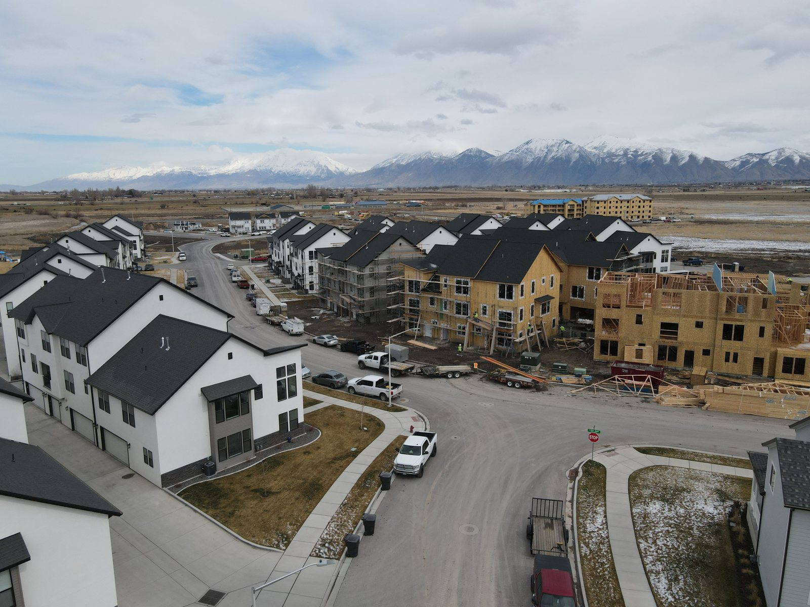 Finished townhomes beside buildings under construction at Arrowhead Park